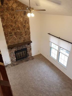 Fairborn condo for rent - A room with a fireplace and a ceiling fan.