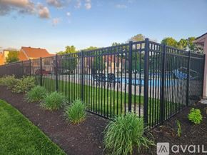 Fairborn condo for rent - A black metal fence surrounds a pool area.
