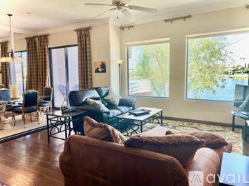 Scottsdale condo for rent - A living room with a brown leather couch and a black coffee table.