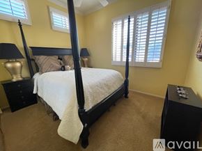 Scottsdale condo for rent - A bedroom with a four poster bed and a window with blinds.