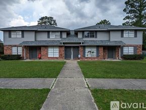 Slidell townhouse for rent - A two-story house with a brick facade and a grey roof.