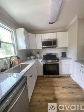 Oxon Hill apartment for rent - A kitchen with white cabinets and a black stove top oven.
