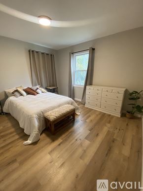 Oxon Hill apartment for rent - A bedroom with a large bed and wooden flooring.