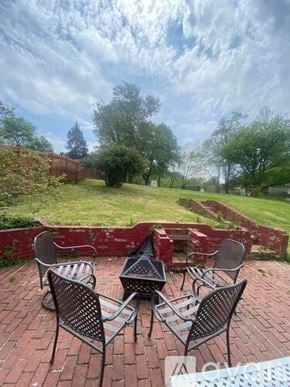 Oxon Hill apartment for rent - Four black metal chairs are arranged in a circle on a brick patio.