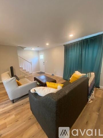 Oxon Hill apartment for rent - A living room with a grey couch and a white chair.
