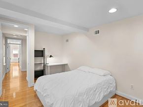 Baltimore townhouse for rent - A bedroom with a bed, a desk, and a ceiling fan.