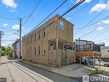 Baltimore townhouse for rent - A kitchen with wooden cabinets and a black microwave above the stove.