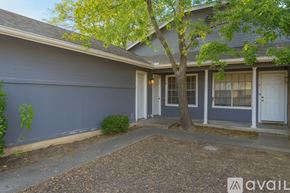 Austin apartment for rent - A house with a blue exterior and a tree in front.