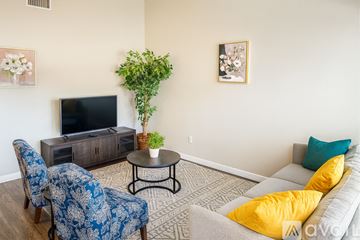 Austin apartment for rent - A living room with a blue chair and a grey couch.