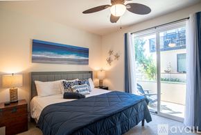Oceanside townhouse for rent - A bedroom with a large bed and a ceiling fan.