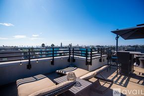 Oceanside townhouse for rent - A sunny day at the rooftop pool with chairs and a table.
