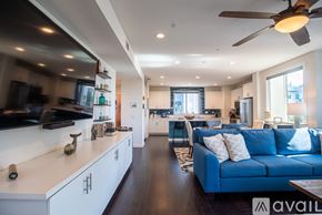 Oceanside townhouse for rent - A modern kitchen with a blue couch and a ceiling fan.