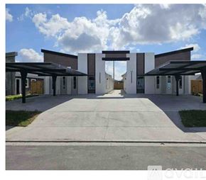 Edinburg apartment for rent - A modern building entrance with a large arched doorway and covered walkway.