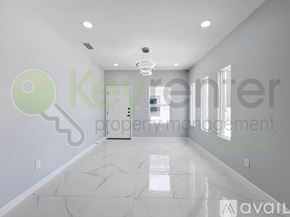 Edinburg townhouse for rent - A spacious room with a marble floor and a key-shaped decoration on the wall.