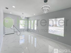 Edinburg townhouse for rent - A spacious, well-lit room with a marble floor and a green door.