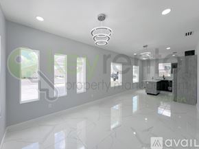 Edinburg townhouse for rent - A spacious, well-lit room with a marble floor and a modern chandelier.