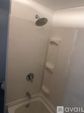 Syracuse apartment for rent - A white shower stall with a shower head and two faucets.