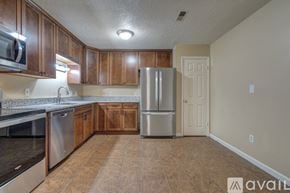 Blacksburg townhouse for rent - A kitchen with wooden cabinets and a stainless steel refrigerator.