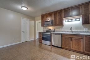 Blacksburg townhouse for rent - A kitchen with wooden cabinets and a tiled floor.