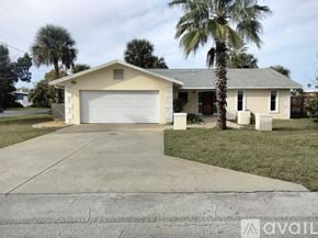 Flagler Beach house for rent - A house with a garage and a palm tree in front.