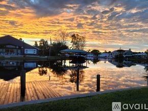 Flagler Beach house for rent - A serene dock with a sunset sky and buildings in the background.