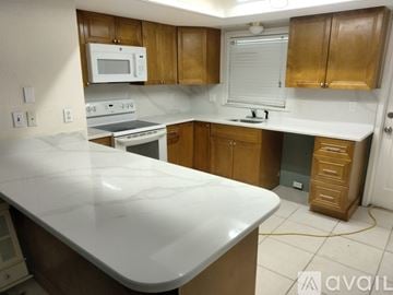 Flagler Beach house for rent - A kitchen with wooden cabinets and a white countertop.