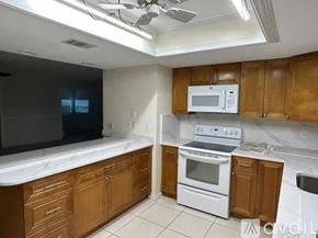 Flagler Beach house for rent - A kitchen with wooden cabinets and white appliances.