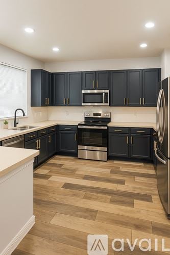 Kissimmee house for rent - A kitchen with black cabinets and a wooden floor.