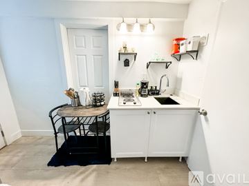Salt Lake City apartment for rent - A small kitchen with a white cabinet and a black chair.