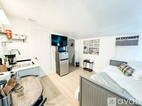 Salt Lake City apartment for rent - A kitchen area with a refrigerator, sink, and a bed in the same room.