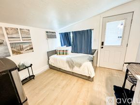 Salt Lake City apartment for rent - A bedroom with a bed, a chair, and pictures on the wall.