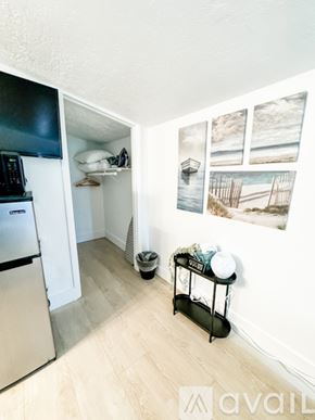 Salt Lake City apartment for rent - A kitchen with a fridge, a stove, a microwave, a fan and a table with a plant on it.