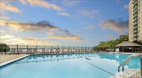Alexandria condo for rent - A large outdoor swimming pool with a sunset sky in the background.