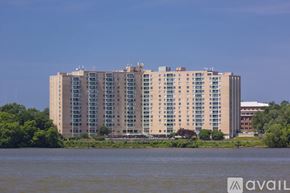Alexandria condo for rent - A large building with many windows sits by a body of water.