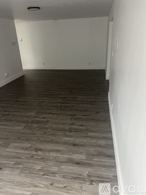 West Palm Beach house for rent - A room with wooden flooring and white walls.