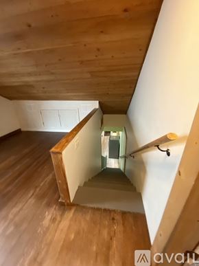 New Orleans apartment for rent - A wooden staircase with a glass railing leads up to a light at the top.