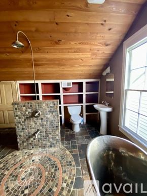 New Orleans apartment for rent - A bathroom with a wooden ceiling and a shower with a brown and tan tile floor.