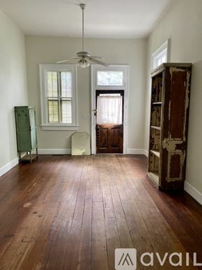 New Orleans apartment for rent - A room with wooden floors and a ceiling fan.