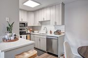 Phoenix apartment for rent - A modern kitchen with a stainless steel dishwasher and white countertops.