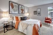 Phoenix apartment for rent - A bedroom with a large bed and a red chair.