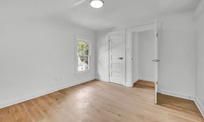 Akron house for rent - A room with a white door and a window with a view of trees and a house.