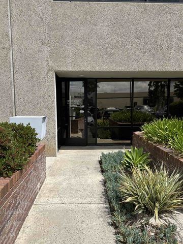 San Diego apartment for rent - A building with a grey wall and a glass door.