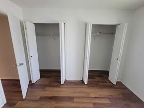 Brownsville apartment for rent - A room with two open closets and wooden floors.