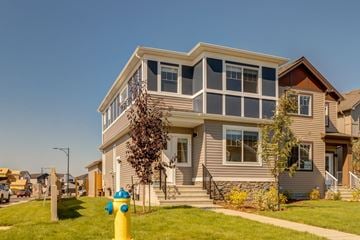 Edmonton apartment for rent - A two-story house with a grey exterior and a yellow fire hydrant in front.