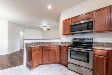 Jacksonville house for rent - A kitchen with brown cabinets and a stainless steel oven.