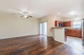 Jacksonville house for rent - A room with wooden floors and a ceiling fan.