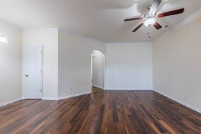 Jacksonville house for rent - A room with a ceiling fan and wooden floors.