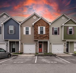 Jacksonville house for rent - A row of houses with garages and a car parked in front.