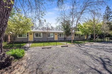 Chico apartment for rent - A house with a gravel driveway and trees in the background.