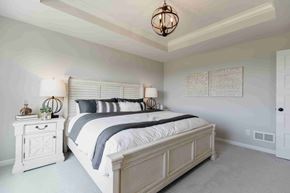 Hastings house for rent - A bedroom with a large bed and a chandelier.